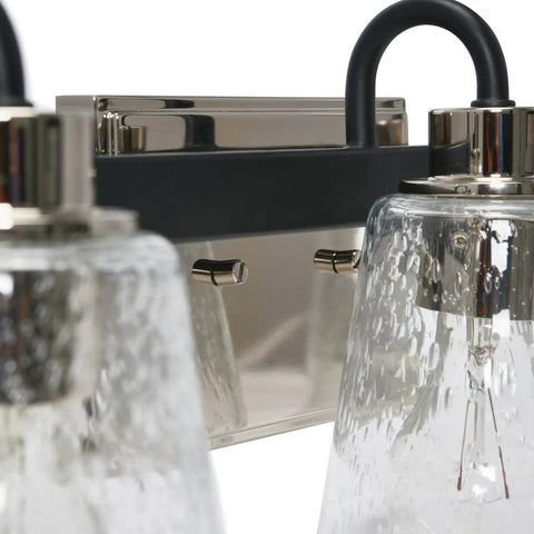 Close-up of Three Light Vanity Fixture With Seeded Glass Diffusers Matte Black Finish With Polished Nickel Accents, Sleek Design