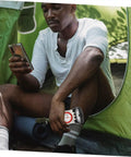 Man using Portable Orienteering Compass With Ruler And Mirror High Accuracy Hiking Map Tool for camping in a green tent