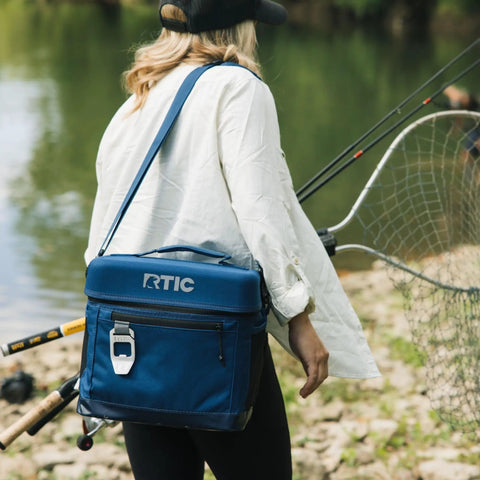 Woman carrying 15 Can Everyday Soft Sided Go To Cooler for Lunch Beach Travel and Camping Insulated Portable Cooler for Men and Women Navy