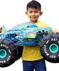 Child holding Mega-Wrex 1 To 6 Scale RC Monster Truck With Extra Large Remote Control, all-terrain tires visible