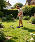 Man using rake on lawn wearing heavy duty lawn aerator shoes with spikes and adjustable straps for outdoor yard maintenance