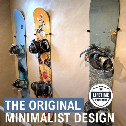 Three snowboards displayed on a wall using a Minimalist Snowboard Wall Mount Display Rack Featuring Felt Padded Arms And Durable Rubber Grip