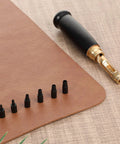 Adjustable Heavy Duty Leather Hole Punch Set With Sturdy Wooden Handle And Six Precision Brass Tips displayed on leather.