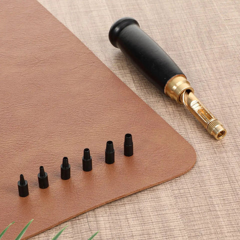 Adjustable Heavy Duty Leather Hole Punch Set With Sturdy Wooden Handle And Six Precision Brass Tips displayed on leather.