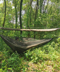 Snakeskin Tarp Sleeve 12ft Camping Rain Fly Storage Kit above a hammock in a forest setting