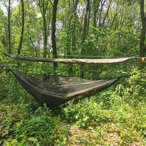 Snakeskin Tarp Sleeve 12ft Camping Rain Fly Storage Kit above a hammock in a forest setting