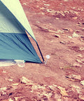 Heavy Duty Tent Stakes Set with Fluorescent Ground Pegs securing tent on hard ground with dark cord for windy beach setup.