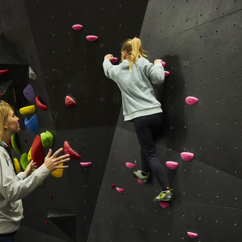 Child climbing wall with pink holds, illustrating Red 10 Screw On Plastic Rock Climbing Holds For Beginners With Hardware Included Easy To Install Ideal For Kids Climbing Walls At Home Durable Safe Fun For Building A Kid Friendly Climbing Wall Experience.