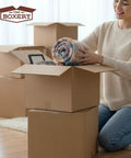 Person packing items into 50 Pack Kraft Corrugated Cardboard Boxes 9 In X 7 In X 5 In for packing mailing and inventory storage.