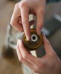 Person holding a rollerblade wheel with Premium Ceramic Bearings Set Of 8 For Skateboards Longboards Inline Skates And Rollerblades.