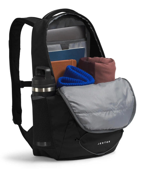 Open Jester Everyday Carry Laptop Backpack For Commuters showing padded laptop sleeve, water bottle, and folded clothes inside, Black NPF.