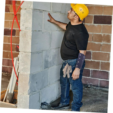 Man wearing Heavy Duty Cut Resistant Wrist Sleeves For Men And Women Beefy Arm Guards while working on a wall.