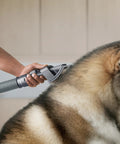 Person using Groom Tool For Upright Vacuums That Makes Pet Hair Cleanup A Breeze With Fine Bristles on a large dog's fur.