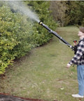 Person using Backpack Mosquito Fogger With Turbo Pump M915 Cold Fogger And Mister Duster spraying foliage in outdoor garden area.