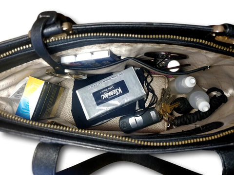 Open handbag with various items, including Discreet Diversion Safe Box Camouflaged Storage 2 Pack Assorted Colors For Cash Cards Keys And Small Valuables Travel Ready Hidden Compartments Perfect For Travel Or Home Everyday Carry Quietly Hide Cash Cards Keys Jewelry.