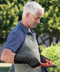 Set Of Three Cut Resistant Arm Sleeves Lightweight Thumb Hole Guards For Yard Work Kitchen Chores Secure Grip Protection Soft Comfort Fit Quick Flip Design No Sweat Daily Carry. Man using arm sleeves while gardening.
