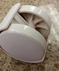 Close-up of almond Chromcraft caster with white plastic wheel and metal stem