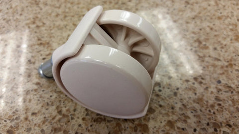 Close-up of almond Chromcraft caster with white plastic wheel and metal stem