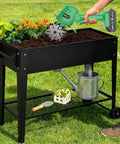 Gardener using 20V Cordless Tiller Cultivator with 2x 2.0Ah Batteries and Charger on raised garden bed.