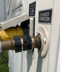 RV city water connection showing a hose attached to a metal fitting on a white vehicle side panel, labeled 'City Water Connection'.