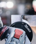 Street Tough 4.5 Inch Angle Grinder Featuring X Lock Tool Free Disc Swap Mount in action, cutting metal with sparks.