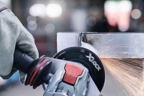 Street Tough 4.5 Inch Angle Grinder Featuring X Lock Tool Free Disc Swap Mount in action, cutting metal with sparks.