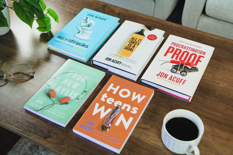 Fresh Start Blueprint A Straight Fire Guide To Level Up Your Life Mindset And Crush Major Changes In This Rock Solid Self Help Manual For Determined Go Getters Ready on a wooden table with glasses and a coffee cup.