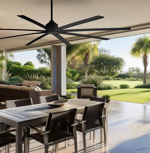 Xtreme H2O 65 Inch Outdoor Ceiling Fan With DC Motor In Coal Finish installed on a patio with chairs and tables, garden view.