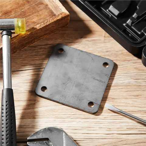 Eight Piece Five By Five Inch A36 Steel Plates One Quarter Inch Thick With Four Holes on workbench with tools around