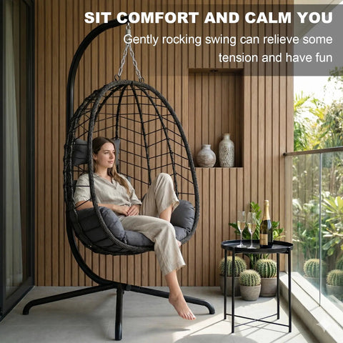 Woman relaxing in Hanging Egg Chair With Stand For Indoor And Outdoor Relaxation Cozy Wicker Hammock Lounge Chair with cushion on balcony.