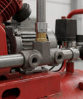 Beefy Four Way Air Compressor Fitting With Cast Iron Cross Adapter installed on a red compressor, showing machined inner threads.