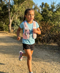 Child running on trail wearing Kids Hydration Backpack With 1L Water Bladder On The Go Adjustable Reflective Running Vest Pink XS S