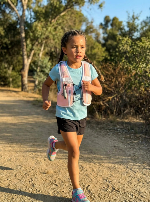 Child running on trail wearing Kids Hydration Backpack With 1L Water Bladder On The Go Adjustable Reflective Running Vest Pink XS S