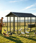 Man feeding poultry near Beefy Large Walk-In Metal Chicken Coop And Outdoor Pet Enclosure Built To Last Heavy-Duty Galvanized Steel Cage 107x72x71 Inches Predator-Proof Locks For Chickens Dogs Rabbits And Ducks.