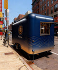 Solid As A Rock Mobile Food Trailer And Rolling Cart Combo Crafted For Coffee Ice Cream Sales Quick Hustle Setup That Grinds Like A Dream On Busy Weekends, blue trailer parked on city street.