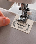 Next Level Custom Cotton Tags Straight Up Premium Fabric Sewing Labels For Quilting Knitting Handmade Clothing Branding Markers Machine Washable Care Instructions 40X50Mm sewn onto fabric with sewing machine.