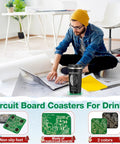 All In One Engineer Gift Set For Men With 17 Oz Stainless Steel Tumbler Circuit Board Cup Mats And Cool Circuit Socks A Practical Thank You Gift For Aerospace Mechanical And Electrical Engineers, featuring a man using a laptop on the floor with a tumbler.