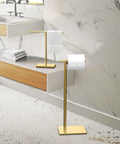 Freestanding Toilet Paper Holder Stand With Weighted Rectangle Base In Brushed Brass Finish For Modern Bathrooms, No Drill Setup, 22.25 Inch Tall in a bathroom setting