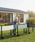 Galvanized Raised Garden Bed On Legs With Wheels For Easy Mobility in backyard, filled with plants, light green color
