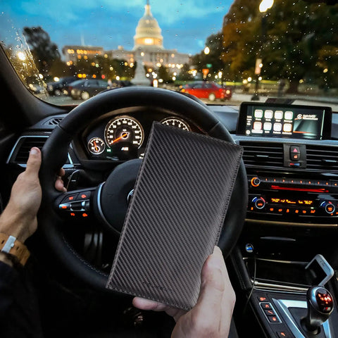 Slick Carbon Fiber Black Car Registration And Insurance Card Holder With Fast Flip Clear Window showcased in a car interior.