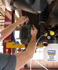 Mechanic using Pro Grade Pneumatic Brake And Clutch Bleeding Kit With Air Operated Action in workshop, close-up