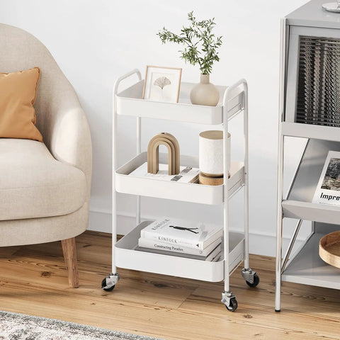 Three Tier Rolling Cart Metal Utility Storage Organizer With Lockable Wheels Space Saving Design Ideal For Kitchen Bathroom Office Nursery Craft Room 33 Lbs Per Shelf Tool Free Assembly In Under Five Minutes White in a living room setting with decorative items on shelves