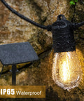 Close-up of IP65 waterproof LED bulb from 68Ft Solar Outdoor String Lights With USB Backup, glowing against rocky background.