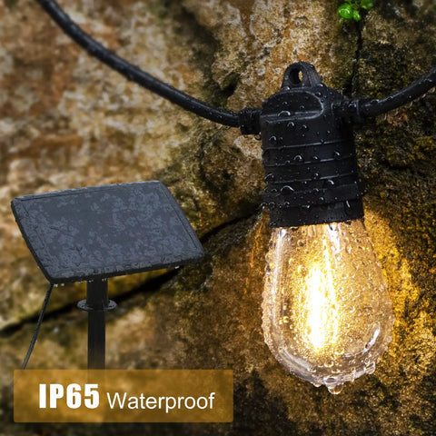 Close-up of IP65 waterproof LED bulb from 68Ft Solar Outdoor String Lights With USB Backup, glowing against rocky background.