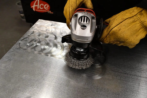Coarse Crimped Wire Cup Brush With Hex Shank For Drill Or Pneumatic Tool, Two Inch Diameter in use on metal surface
