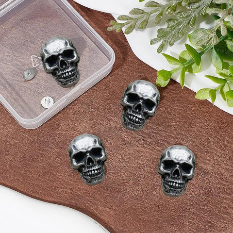 Four Kickass Punk Skull Screw Back Brass Rivets For Leather Crafting Hardware on brown leather background.