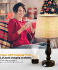 Cool Set Of 2 Table Lamps With USB Ports, Dimmable Touch Control, linen lampshade on a table beside a woman using a phone.