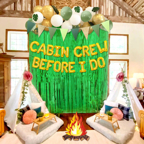 Before I Do Cabin Crew Bachelorette Party Sign Banner with balloons, tipi tents, and indoor campfire setup for celebrations.