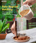 Chew Proof Metal Bird Feeder with Copper Finish being refilled outdoors. Features wide-mouth opening and weather-resistant design.