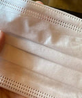Hand holding Made In USA 3 Layer Disposable Face Masks Bulk Pack 500 Count 6.69 Inches Long By 3.74 Inches Wide With Ear Loop Medical Procedure Masks And Meltblown Filter Layer.